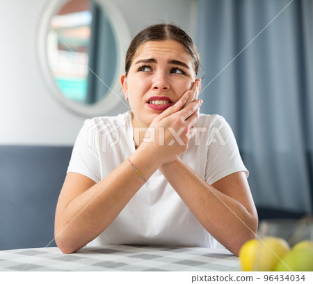 Portrait of a young girl suffering from toothache Portrait of a young girl suffering from toothache 96434034