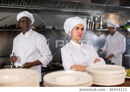 Woman head chef posing in restaurant kitchen 96434112