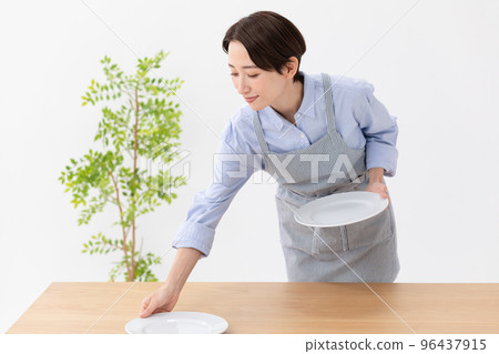 女人把盤子放在桌子上 女人把盤子放在桌子上 96437915