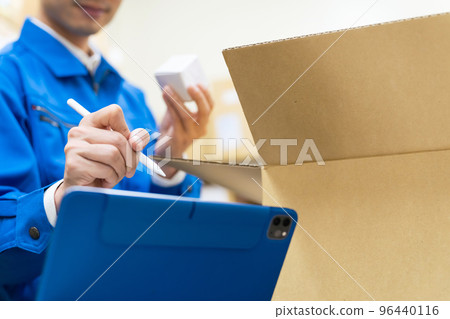 A man who inspects luggage and checks it on a tablet PC 96440116
