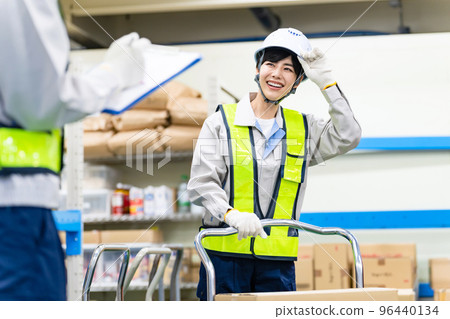 Employees passing each other with a smile at the work site 96440134