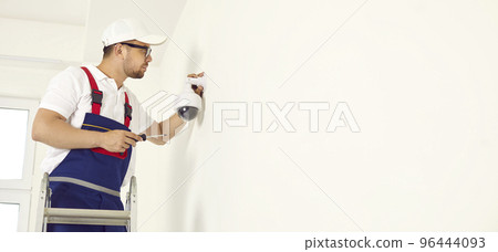 Mounting security 360 camera on wall of house. Ensuring the security of the office space. Mounting security 360 camera on wall of house. Ensuring the security of the office space. 96444093