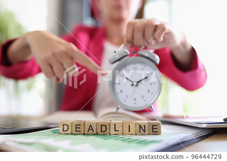 Businesswoman pointing with finger on alarm clock 96444729