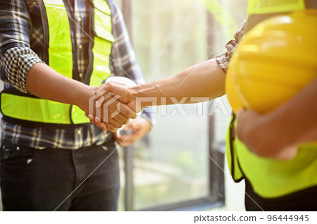 Professional construction engineer or worker shaking hands with his coworker. close-up Professional construction engineer or worker shaking hands with his coworker. close-up 96444945