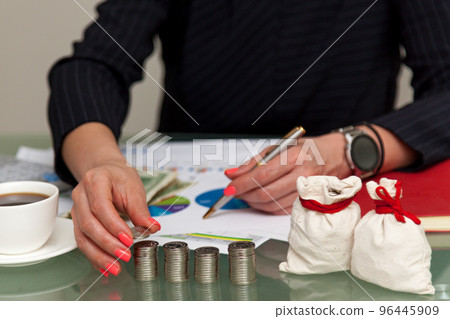 Girl with money at the table 96445909