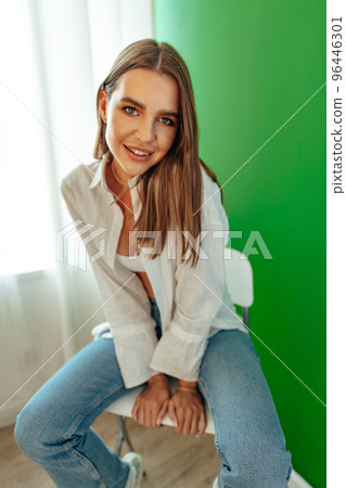 Portrait of attractive lovely girl wearing crop top and shirt posing over green studio background 96446301