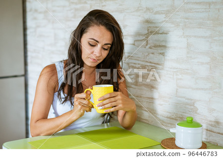 Cute woman in the kitchen with a mug of tea 96446783
