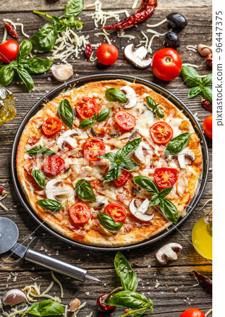 Pizza decorated with basil leaves 96447375