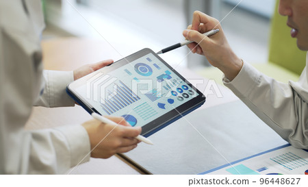 People looking at a tablet screen and talking People looking at a tablet screen and talking 96448627