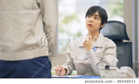 Boss wearing work clothes talking to subordinates in the office 96448631