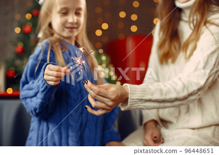 People reparing for Christmas. Kid with bengal lights. Family is resting in a festive room. Child in a blue sweater. People reparing for Christmas. Kid with bengal lights. Family is resting in a festive room. Child in a blue sweater. 96448651