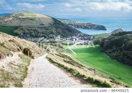 Stone road to Durdle door in Lulworth, part of Jurassic Coast World Heritage Site, view of the seaside cottages and Lulworth Cove in the background, selective focus Stone road to Durdle door in Lulworth, part of Jurassic Coast World Heritage Site, view of the seaside cottages and Lulworth Cove in the background, selective focus 96448825