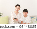 mother and daughter using remote control 96448885