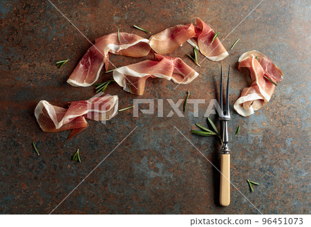Prosciutto with rosemary on vintage background. 96451073