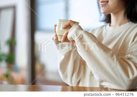 Asian woman relaxing with a drink Asian woman relaxing with a drink 96451276