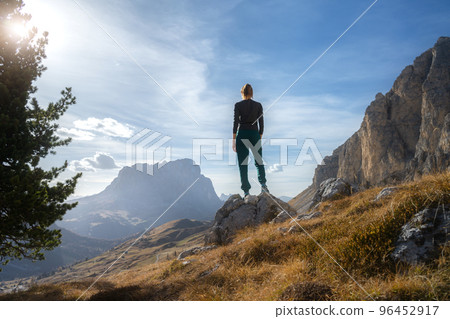 Woman on the stone on mountain trail at sunset in autumn 96452917