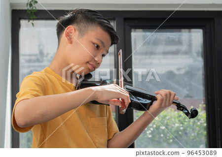 A Little Asian kid playing and practice violin musical string instrument against in home, Concept of Musical education, Inspiration, Teenager art school student. A Little Asian kid playing and practice violin musical string instrument against in home, Concept of Musical education, Inspiration, Teenager art school student. 96453089