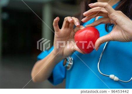 Female Cardiovascular disease doctor or cardiologist with stethoscope holding red heart, Medical health care and doctor staff service concept. Female Cardiovascular disease doctor or cardiologist with stethoscope holding red heart, Medical health care and doctor staff service concept. 96453442