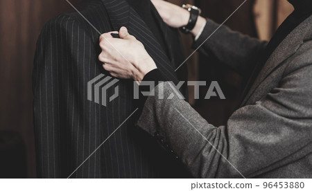Tailor working on custom made suit Tailor working on custom made suit 96453880