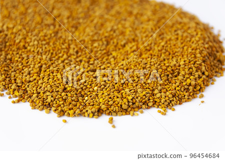 Crumbled bee pollen granules on white background. Crumbled bee pollen granules on white background. 96454684