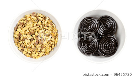Liquorice root chips and Liquorice wheels in white bowls. Dried and cut root of Glycyrrhiza glabra, as an extract the main flavor of licorice confection, usually colored black and rolled into spirals. Liquorice root chips and Liquorice wheels in white bowls. Dried and cut root of Glycyrrhiza glabra, as an extract the main flavor of licorice confection, usually colored black and rolled into spirals. 96455720
