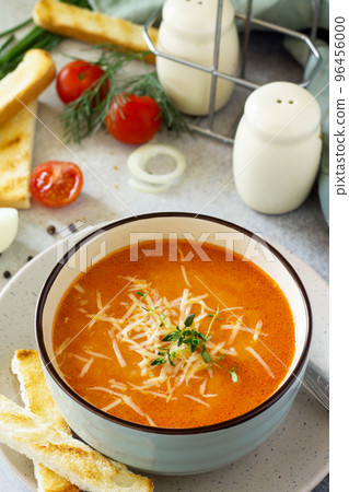 Puree soup tomato with croutons and cheese in a bowl on a light slate background. The concept of healthy eating. Diet menu. 96456000