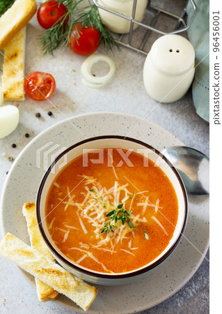 Puree soup tomato with croutons and cheese in a bowl on a light slate background. The concept of healthy eating. Diet menu. Copy space. 96456001