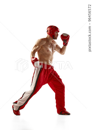 Young professional kickboxer wearing helmet and boxing gloves in motion isolated on white background. Sport, competition, energy, combat sports 96456572