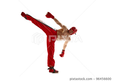 Leg kick. Young professional kickboxer wearing helmet and boxing gloves in motion isolated on white background. Sport, competition, energy, combat sports Leg kick. Young professional kickboxer wearing helmet and boxing gloves in motion isolated on white background. Sport, competition, energy, combat sports 96456600