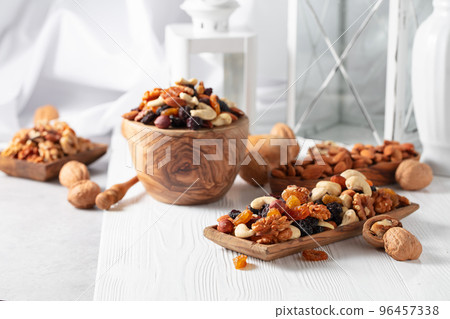 Mix of nuts and raisins on a white wooden table. 96457338