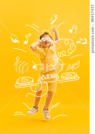 Creative design with drawn elements. Portrait of happy little boy, child posing over yellow background. Future dj, musician Creative design with drawn elements. Portrait of happy little boy, child posing over yellow background. Future dj, musician 96457435