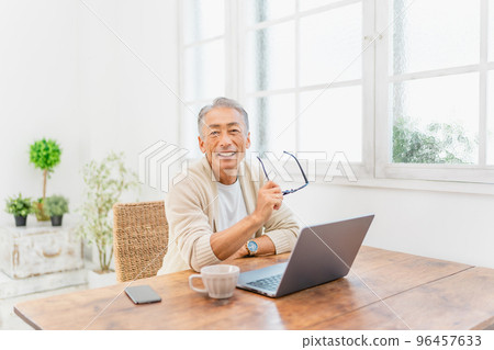 A man looking at a computer in the living room　 96457633
