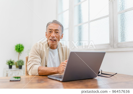 一個男人在客廳看電腦 96457636