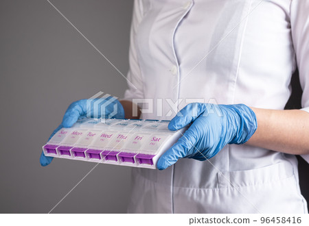 Doctor hands holding pill box, tablets medicines organizer. Medical prescription concept Doctor hands holding pill box, tablets medicines organizer. Medical prescription concept 96458416