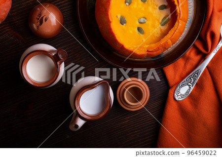 baked pumpkin cream coup served in pumpkin with corn. served at wooden brown table with ripe orange pumkins. flat lay. healthy life concept baked pumpkin cream coup served in pumpkin with corn. served at wooden brown table with ripe orange pumkins. flat lay. healthy life concept 96459022