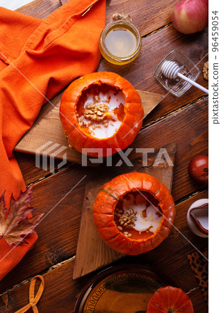 baked pumpkin cream coup with cream and nuts served in pumpkins. served at wooden rural brown table for 2 person . cooking recipe. healthy life concept. flat lay baked pumpkin cream coup with cream and nuts served in pumpkins. served at wooden rural brown table for 2 person . cooking recipe. healthy life concept. flat lay 96459054