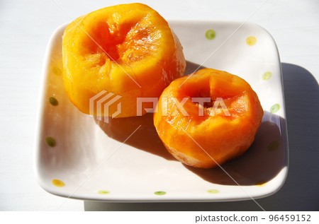 一個柿子笨拙地剝下來放在盤子裡 96459152