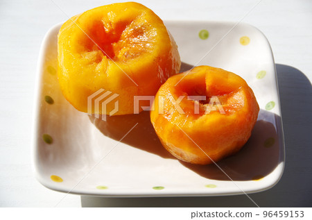 一個柿子笨拙地剝下來放在盤子裡 96459153