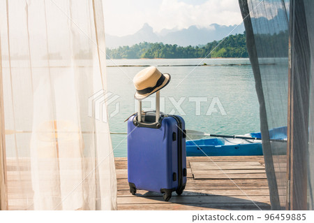 Time to Travel and Relax, Travel suitcase with hat standing on the floor out the bedroom at the lake and beach. 96459885