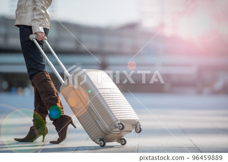 Young businesswoman walking with luggage, suitcase at the airport for travel trip. Young businesswoman walking with luggage, suitcase at the airport for travel trip. 96459889