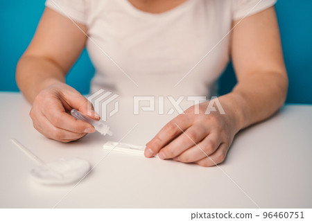 woman using rapid antigen test kit for self test COVID-19 epidemic at home. Adult female unpacking a swab for inserts into her nose. COVID-19 coronavirus pandemic protection concept. woman using rapid antigen test kit for self test COVID-19 epidemic at home. Adult female unpacking a swab for inserts into her nose. COVID-19 coronavirus pandemic protection concept. 96460751