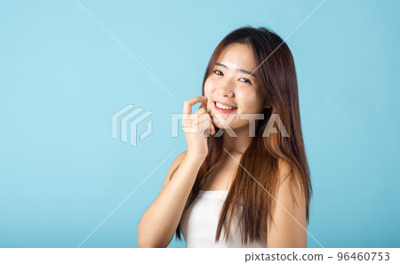 Skin care and Beauty concept. Portrait happy woman with natural makeup and healthy face studio shot isolated on blue background, Asian young female with beauty face touching healthy facial skin Skin care and Beauty concept. Portrait happy woman with natural makeup and healthy face studio shot isolated on blue background, Asian young female with beauty face touching healthy facial skin 96460753