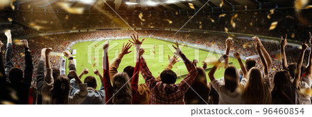 Victory. Back view of football soccer fans cheering their team with colorful scarfs at crowded stadium at evening time. Concept of sport, cup, world, team, event, competition 96460854