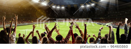 Back view of group of people, football soccer fans cheering at crowded football stadium at evening time. Concept of sport, cup, world, team, event, competition 96460860