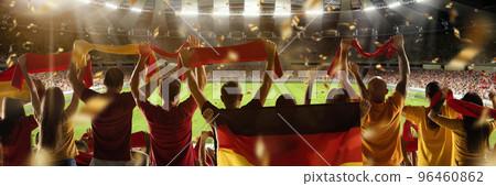 Winner emotions. Back view of football soccer fans cheering their team with colorful scarfs at crowded stadium. Concept of sport, cup, world, emotion, event, competition Winner emotions. Back view of football soccer fans cheering their team with colorful scarfs at crowded stadium. Concept of sport, cup, world, emotion, event, competition 96460862