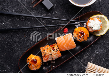 sushi roll set served at black tray with black sticks at black table. flat lay. sushi roll set served at black tray with black sticks at black table. flat lay. 96460949