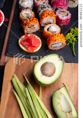 sushi cooking set with rice and ingredients served at black dish at black table. flat lay sushi cooking set with rice and ingredients served at black dish at black table. flat lay 96461215