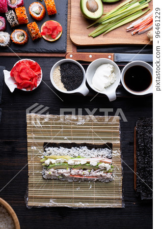 sushi cooking set with rice and ingredients served at black dish at black table. flat lay sushi cooking set with rice and ingredients served at black dish at black table. flat lay 96461229
