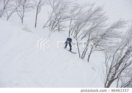 A snowboarder taking pictures of the eastern slopes of the hike destination at Lotte Arai Resort ski resort in Myoko City, Niigata Prefecture A snowboarder taking pictures of the eastern slopes of the hike destination at Lotte Arai Resort ski resort in Myoko City, Niigata Prefecture 96461357