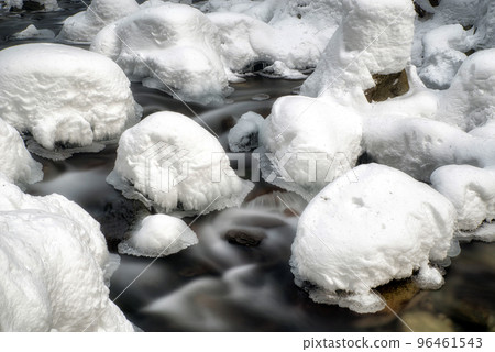 Long exposure of flowing cold frozen water in mountain stream Long exposure of flowing cold frozen water in mountain stream 96461543